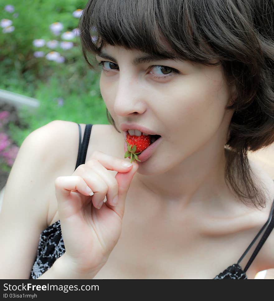 Portrait of woman eating strawberries.