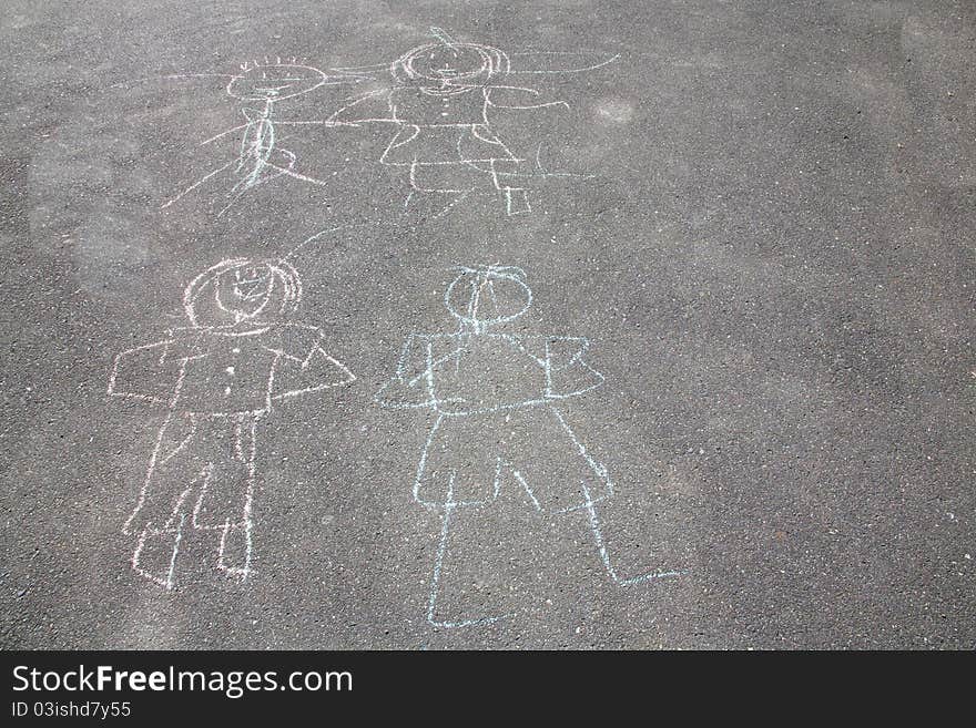 A chalk drawing of people on a sidewalk done by children. A chalk drawing of people on a sidewalk done by children