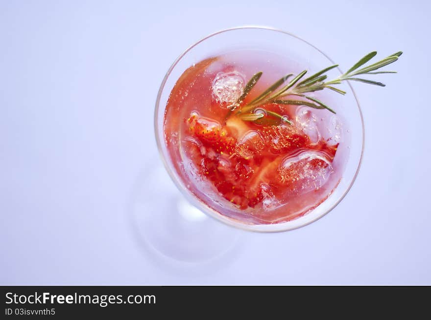 Strawberry cocktail with ice and rosemary twig