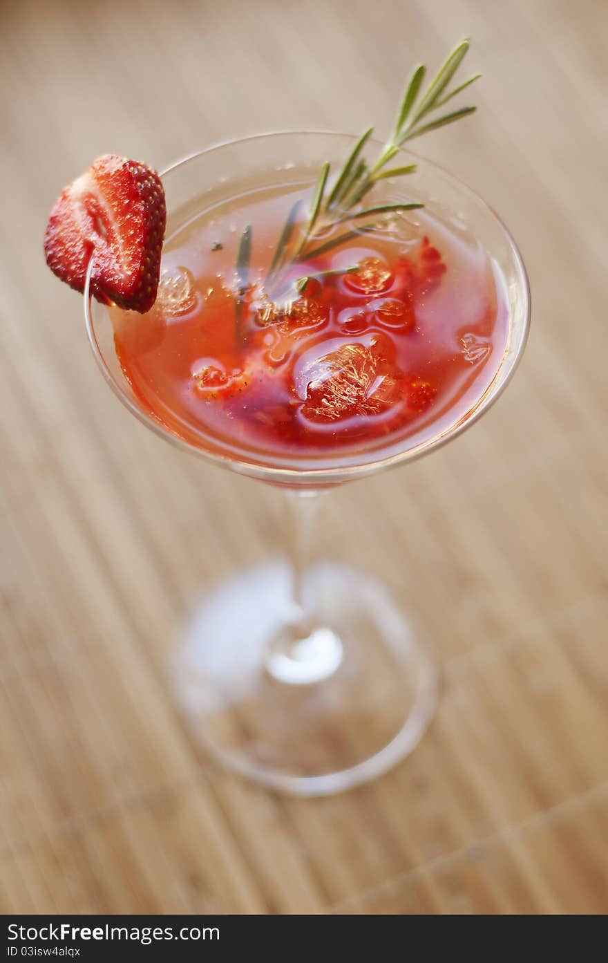 Strawberry cocktail with ice and rosemary twig