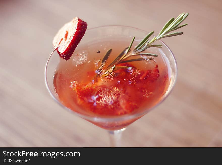 Strawberry cocktail with ice and rosemary twig