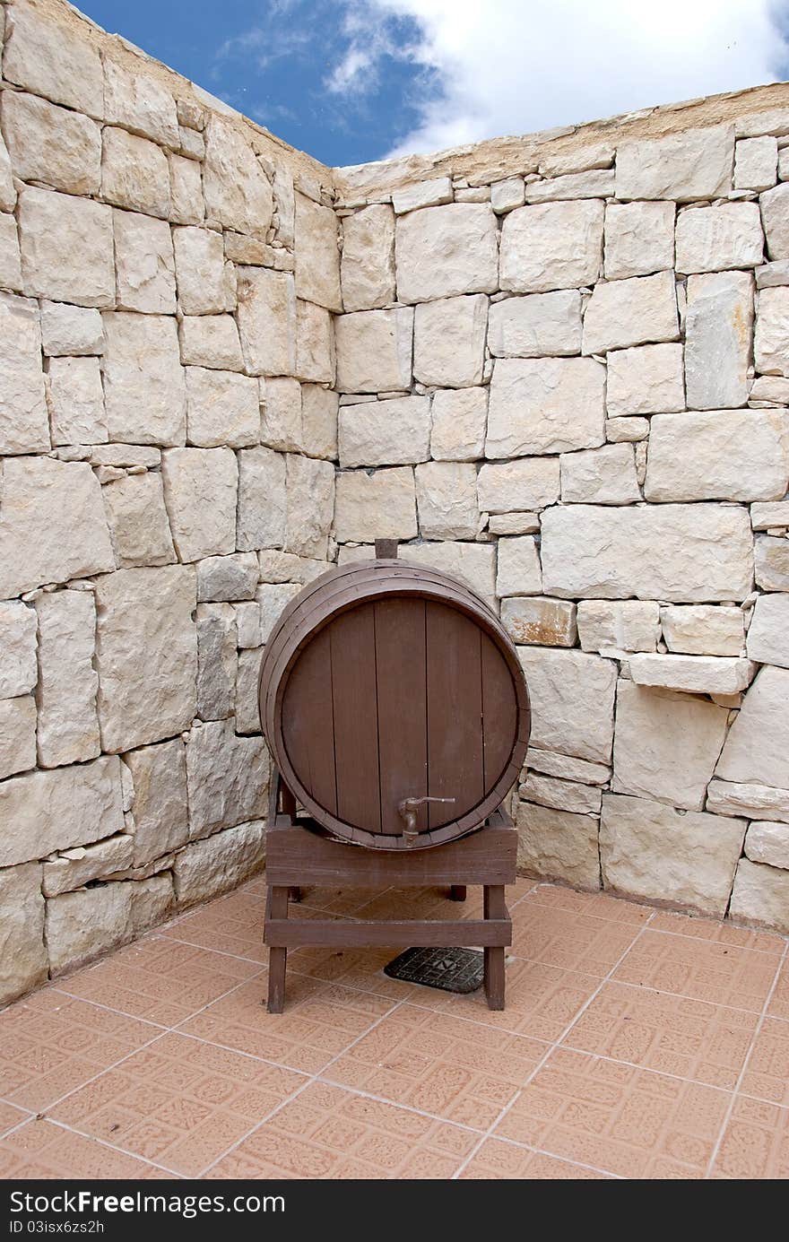 An old Wine Barrel in a Greek Courtyard under a blue summer Sky