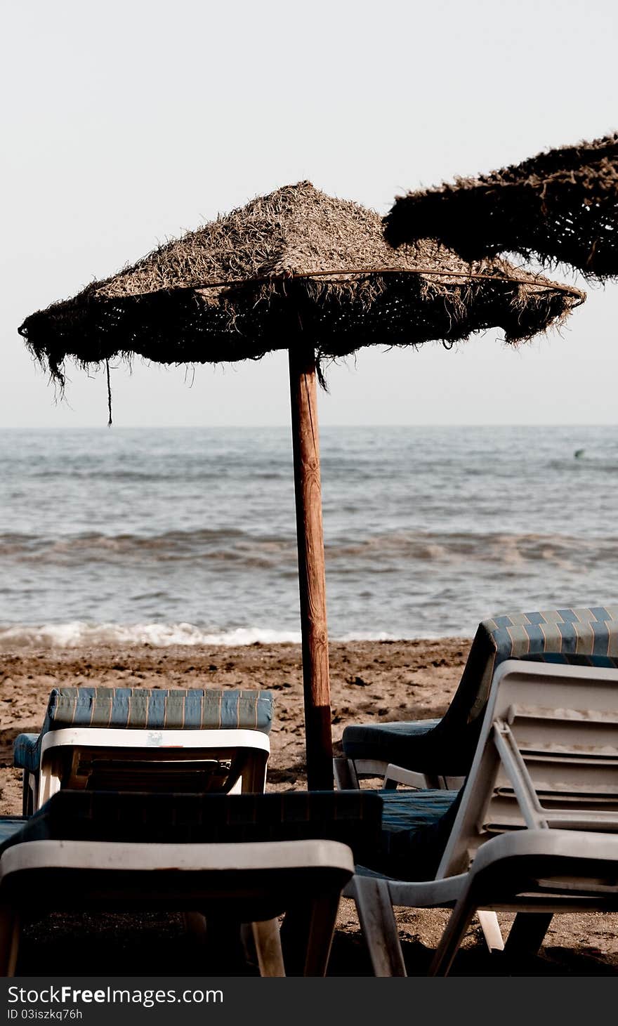 Straw umbrella and chairs