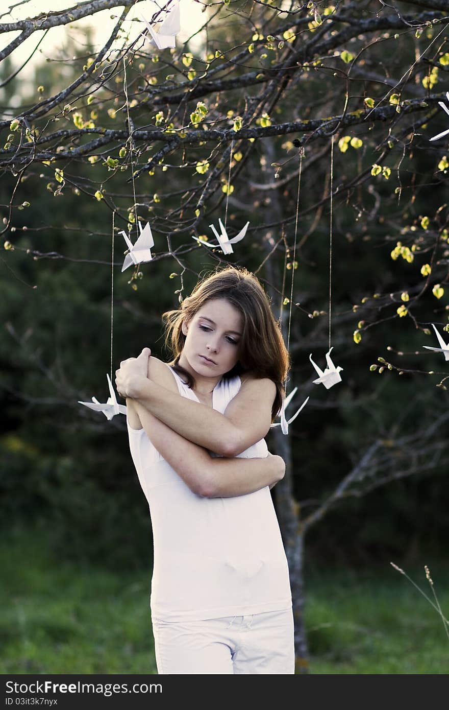 A portrait of a young woman standing in the forest