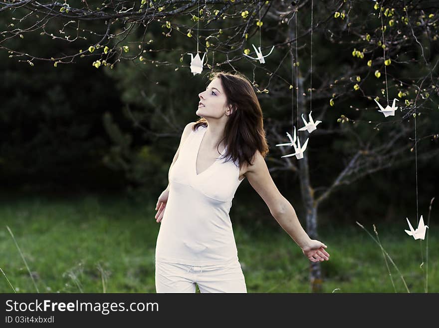 A young woman with the arms stretched in the park