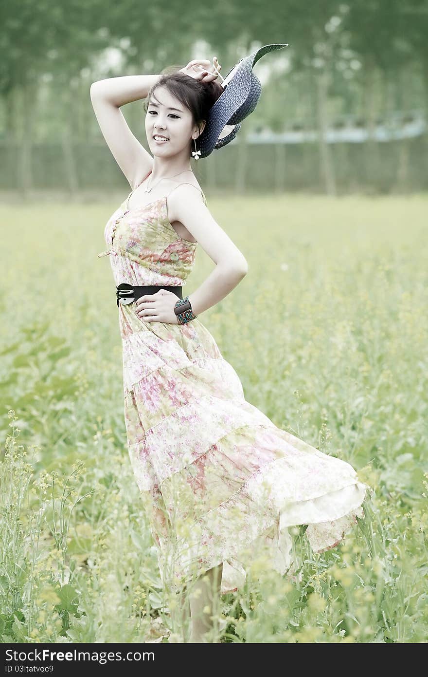 Charming Asian model posing in field. Charming Asian model posing in field.