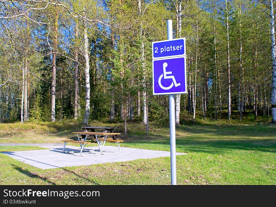 Bench In The Park And A Sign For Disabled