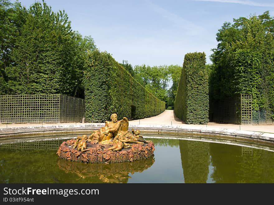 Bassin de Saturne fountain in Versailles Palace garden, city Paris, France. The Palace Versilles is a royal chateau, It was added to the UNESCO list of World Heritage Sites in 1979.