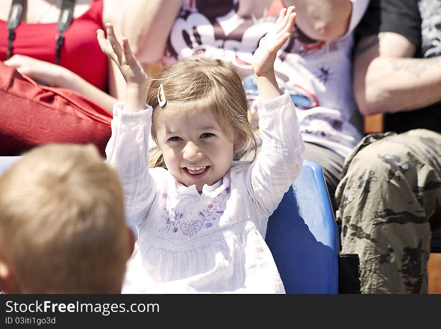 Happy girl watching show and clapping her hands