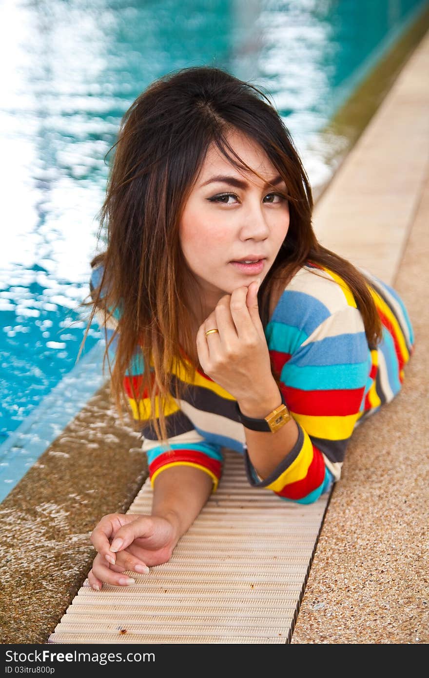 Young woman relaxing beside swimming pool.