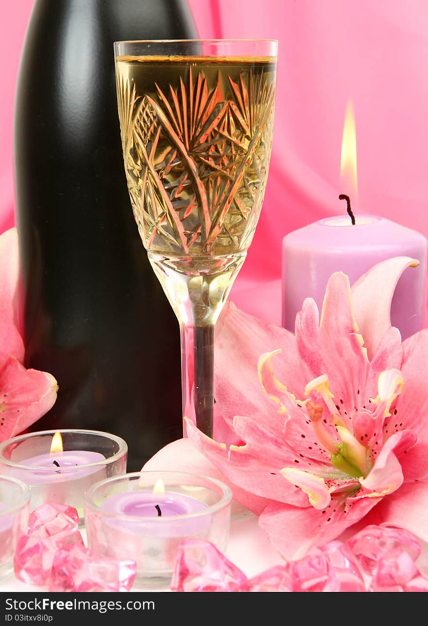 Wine and candles on a pink background