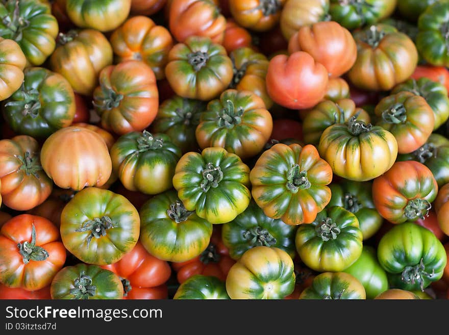 Fresh Italian Costoluto tomatoes on display at an outdoors farmers' market stall