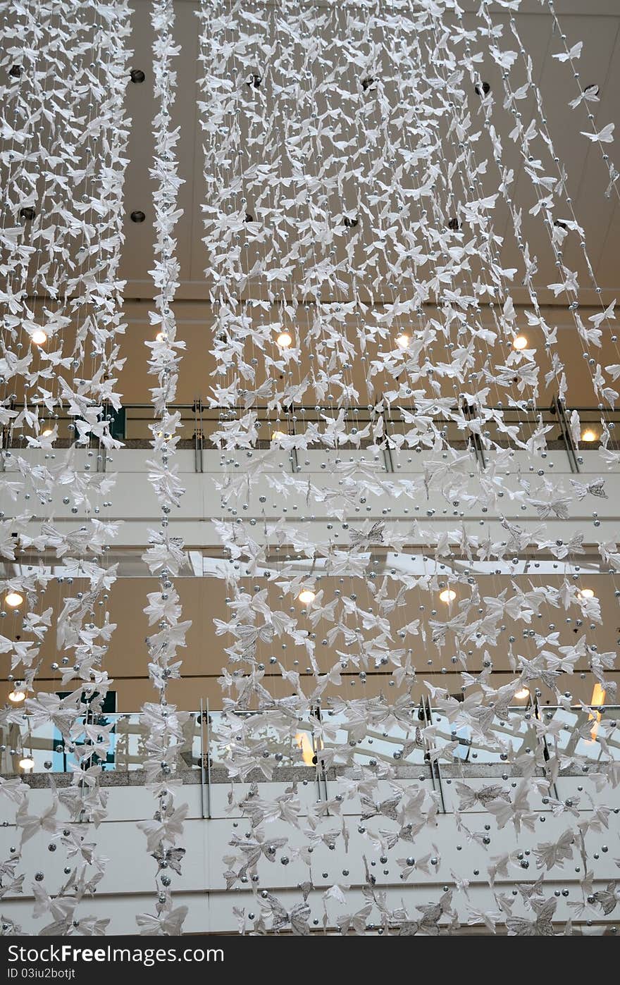 This is shot inside a shopping mall. Many white butterflies made up from spun silk. This is shot inside a shopping mall. Many white butterflies made up from spun silk.