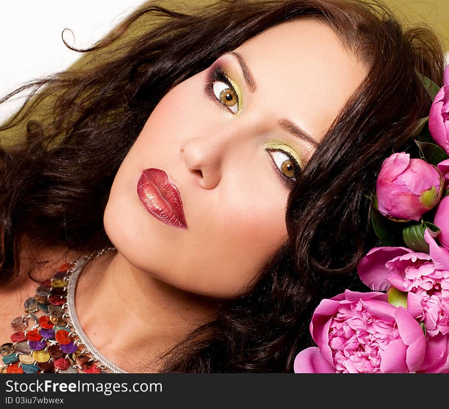 Porrait of beautiful young woman with art make up and flowers