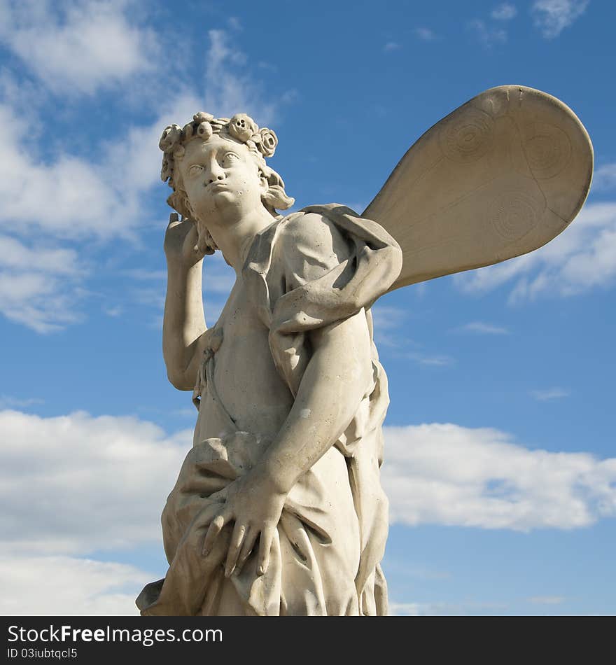 Ancient sculpture angel in the blue sky. Russia, Peterhof, St. Petersburg