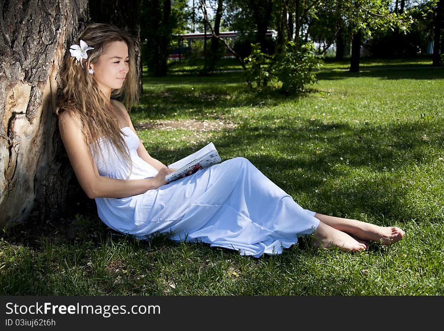 Young Woman Reading Book In Park