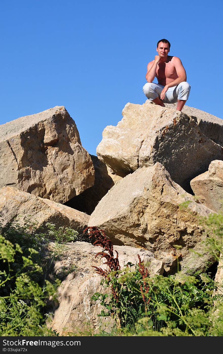 A man sits on a pile of stones