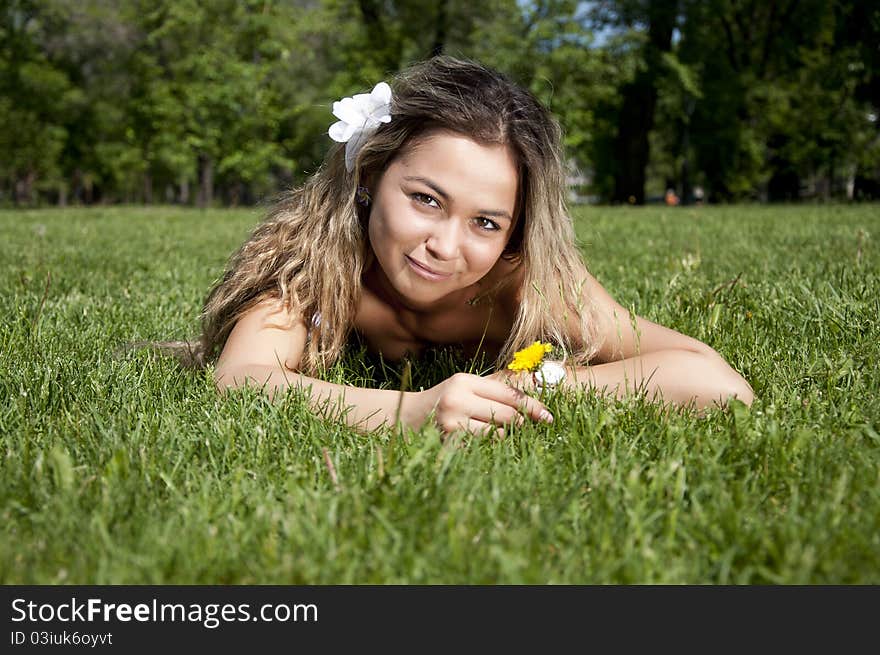 Portrait of the young woman lying on a grass in summer. Portrait of the young woman lying on a grass in summer