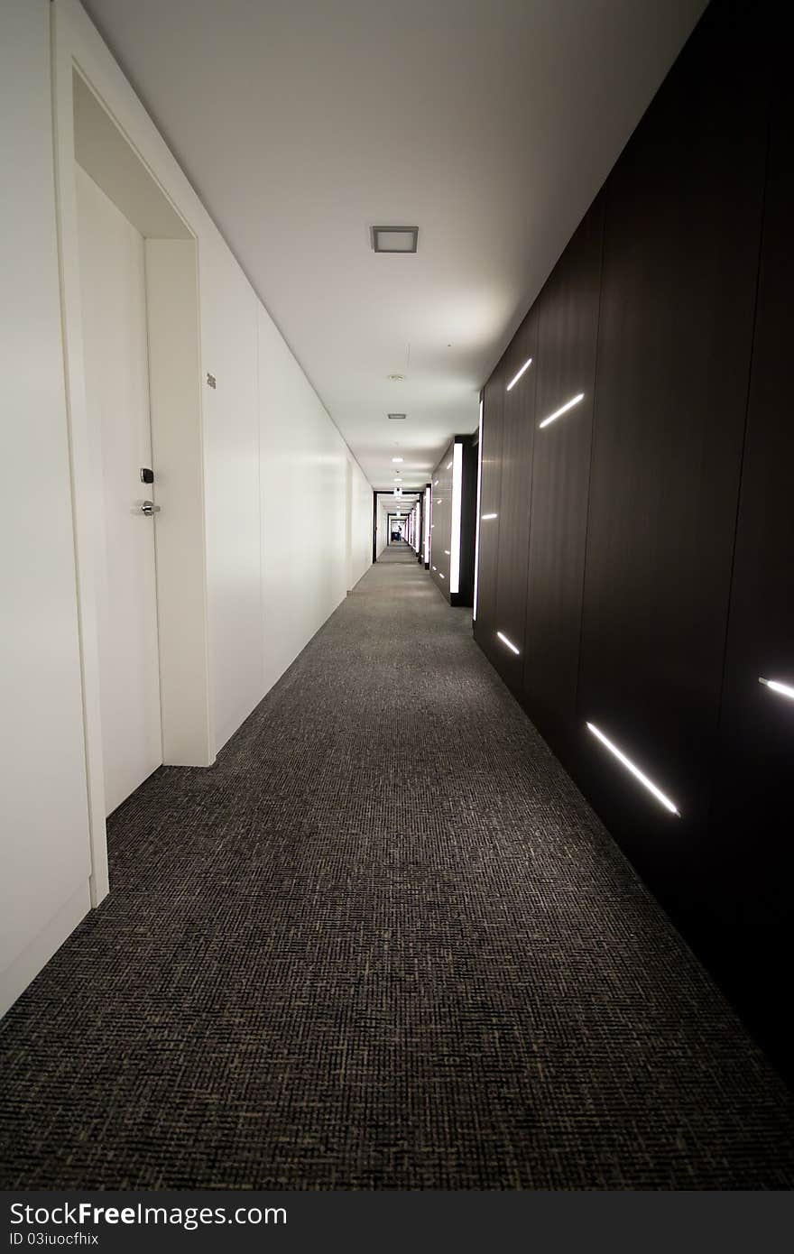 Hotel corridor well iluminated with a wall in white