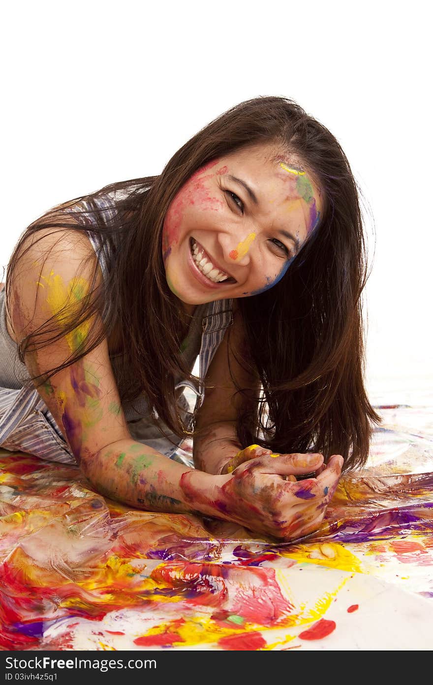 A woman laying in paint with a happy expression on her face. A woman laying in paint with a happy expression on her face.