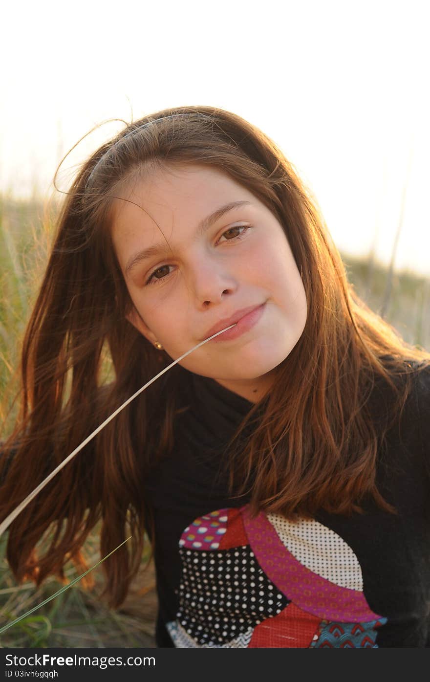 Young girl with straw of grass