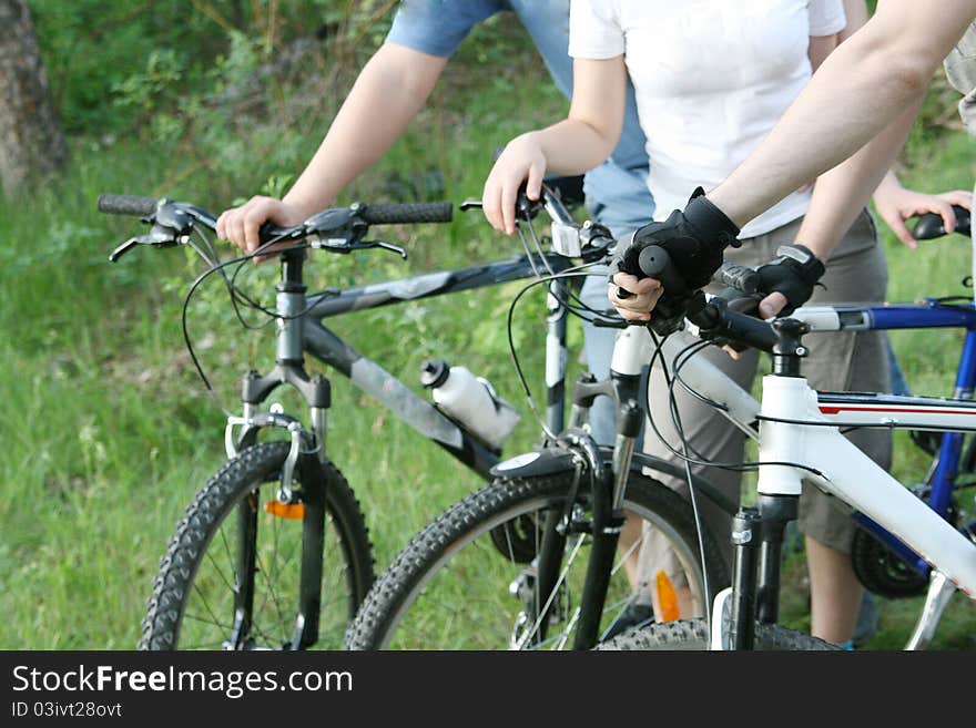 Three cyclists resting on bikes