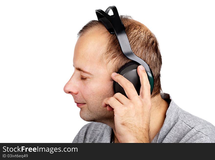 Young man listening to the music in headphones isolated on white. Young man listening to the music in headphones isolated on white