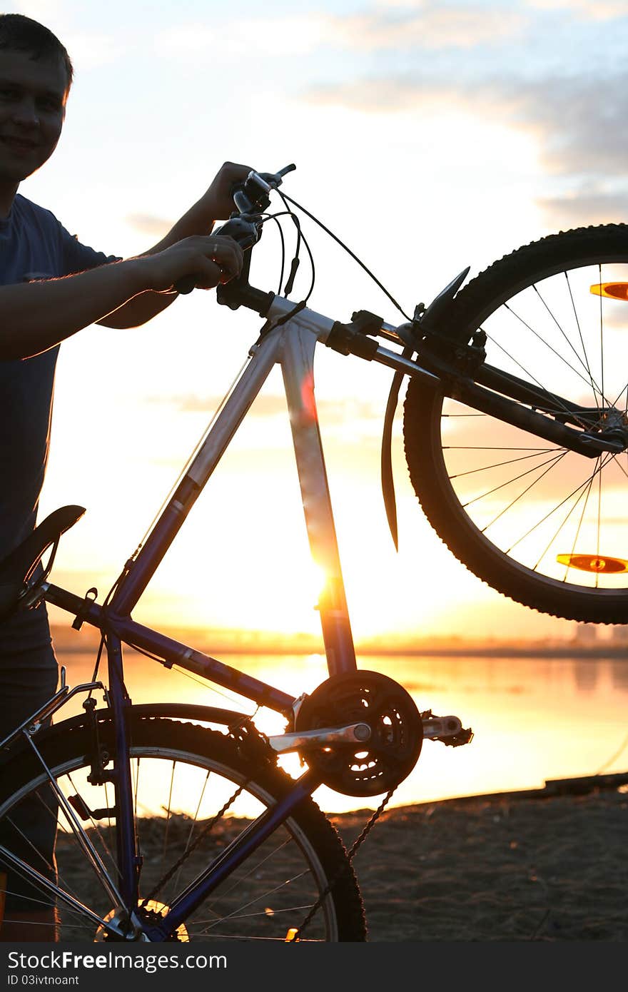 Silhouette of a cyclist on the background of the lake