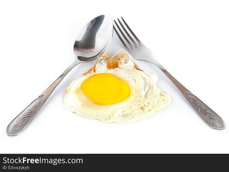 Fried egg with a spoon and fork