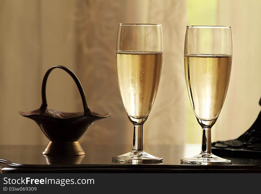 Two glasses of champagne on abstract yellow background