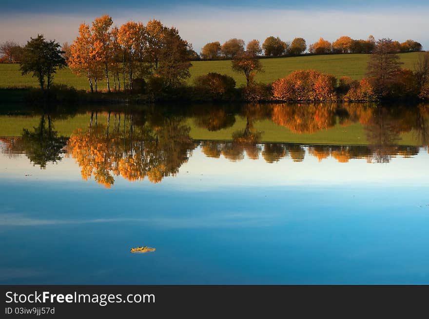 Autumn pond behind sunny weather.