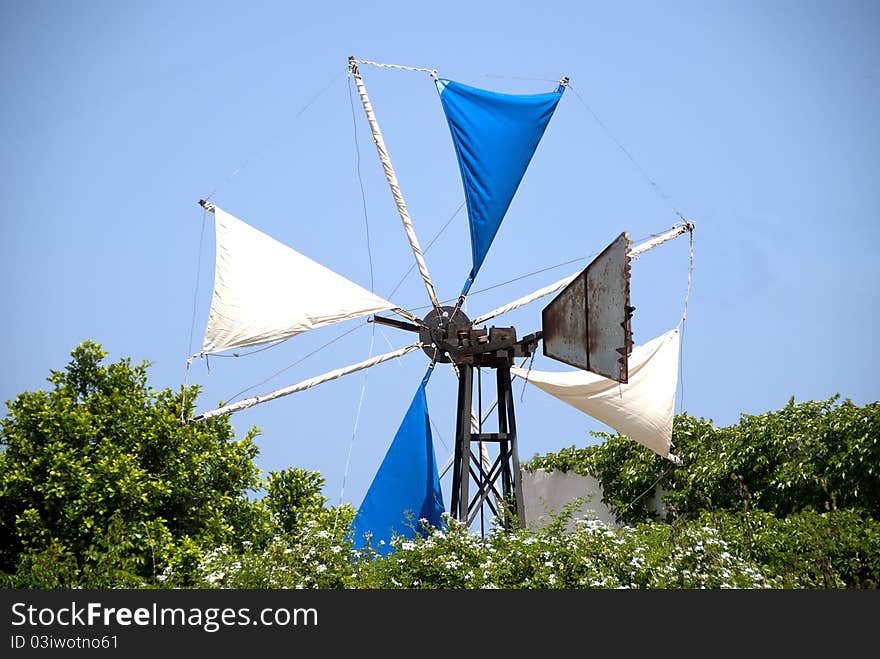 The Sails of a Greek Windmill surrounded by Jasmine Flowers