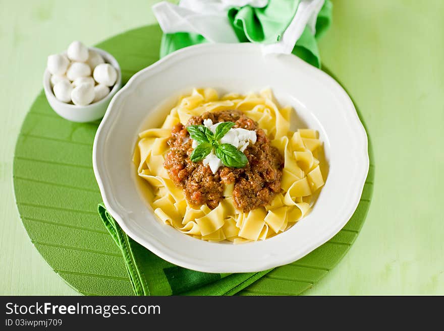 Delicious pasta with tomato meat sauce and mozzarella chips over it