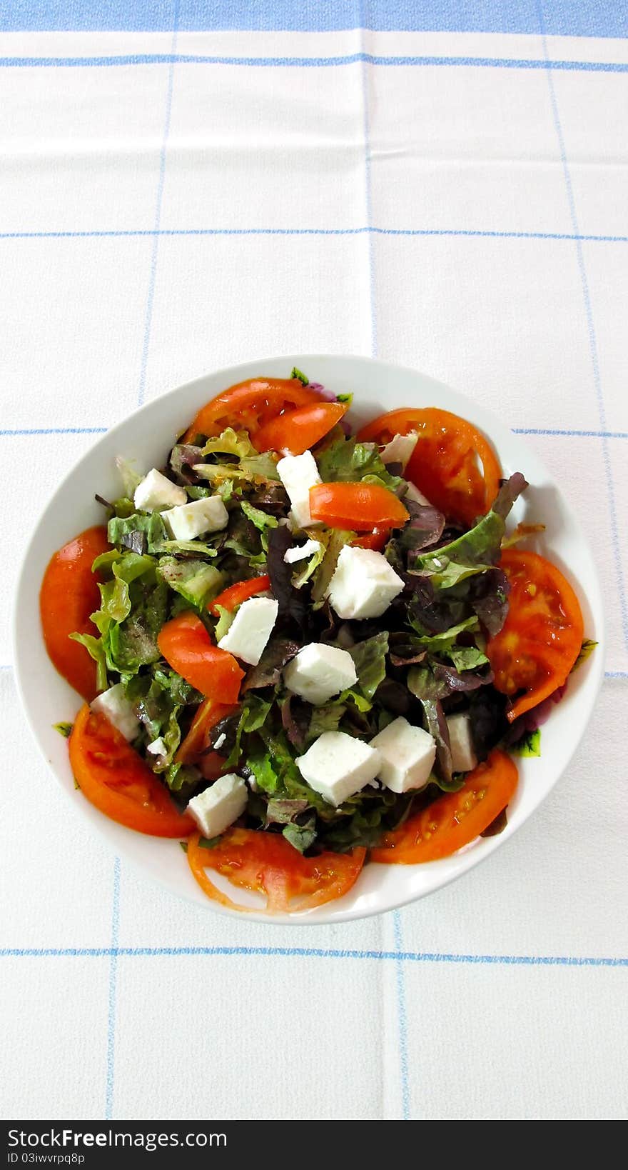 A plate with vegetables and feta cheese. A plate with vegetables and feta cheese