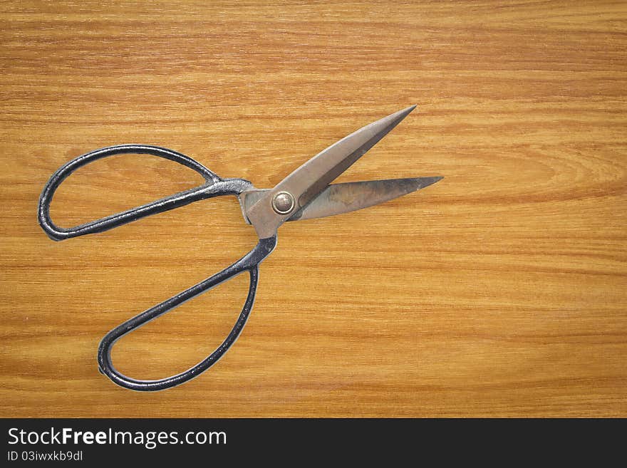 Rusty old Scissor on wood board background