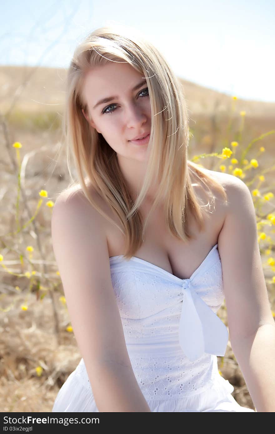 Blonde model in field with white dress