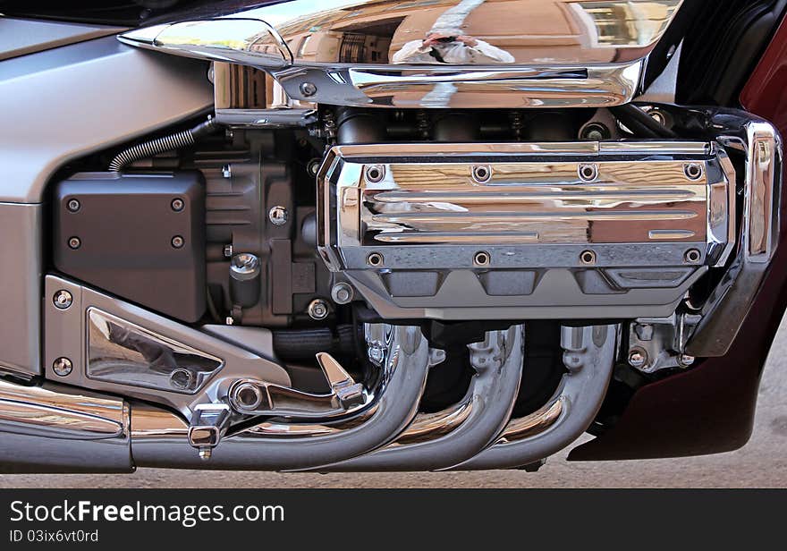 A closeup detailed view of chrome exhaust pipes and engine components on a big chopper bike. A closeup detailed view of chrome exhaust pipes and engine components on a big chopper bike.