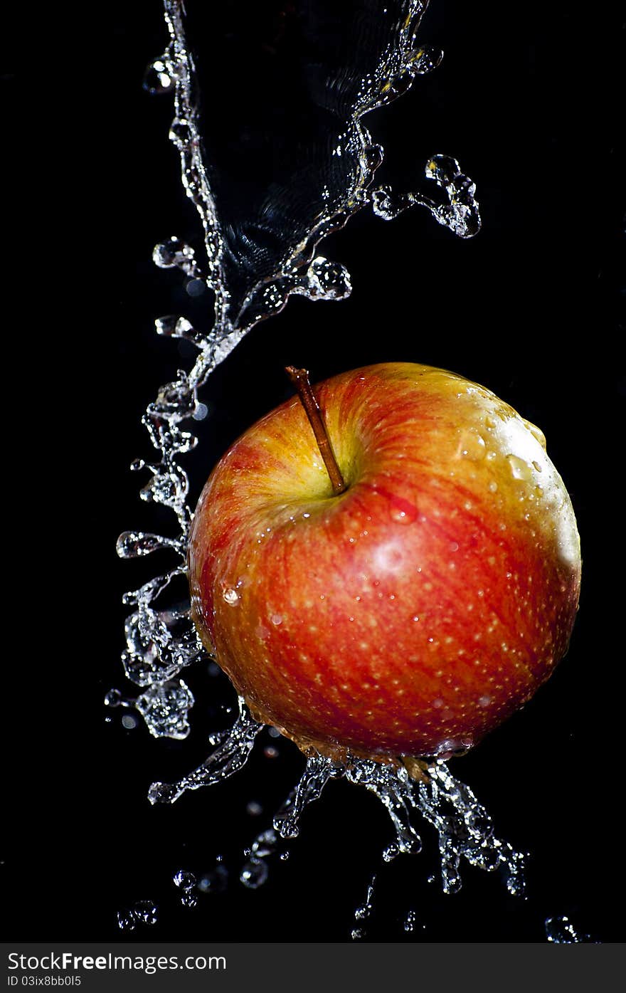 Fresh apple and water splash over black background. Fresh apple and water splash over black background