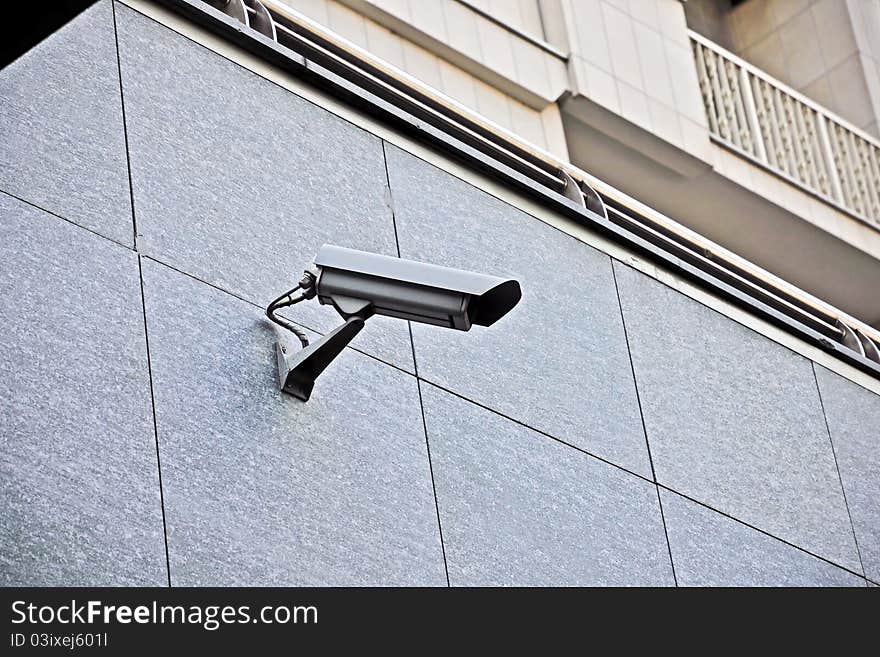 Surveillance camera - A surveillance camera mounted on a wall to control a public place.