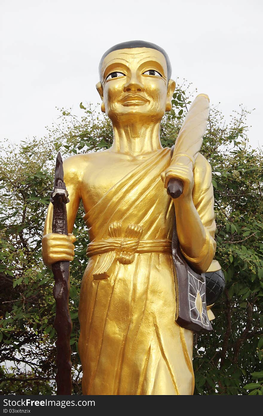 Standing Buddha with stick and a bag at a Wat in Pattaya, Thailand