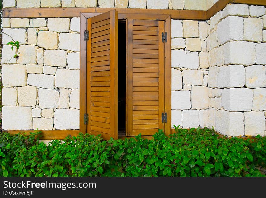 Parted wood shutters in a stone house. Parted wood shutters in a stone house