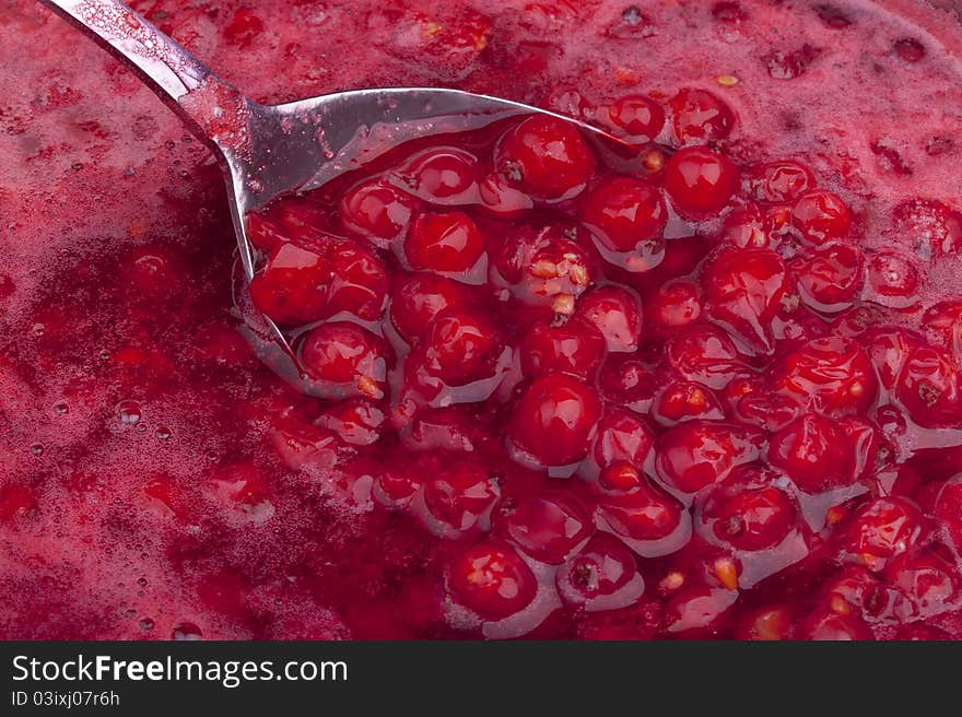 Studio-shot of cooking and preparing homemade red currant jelly in a pot.