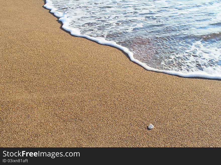 Golden sand beach lapped by the waves of the sea. Golden sand beach lapped by the waves of the sea