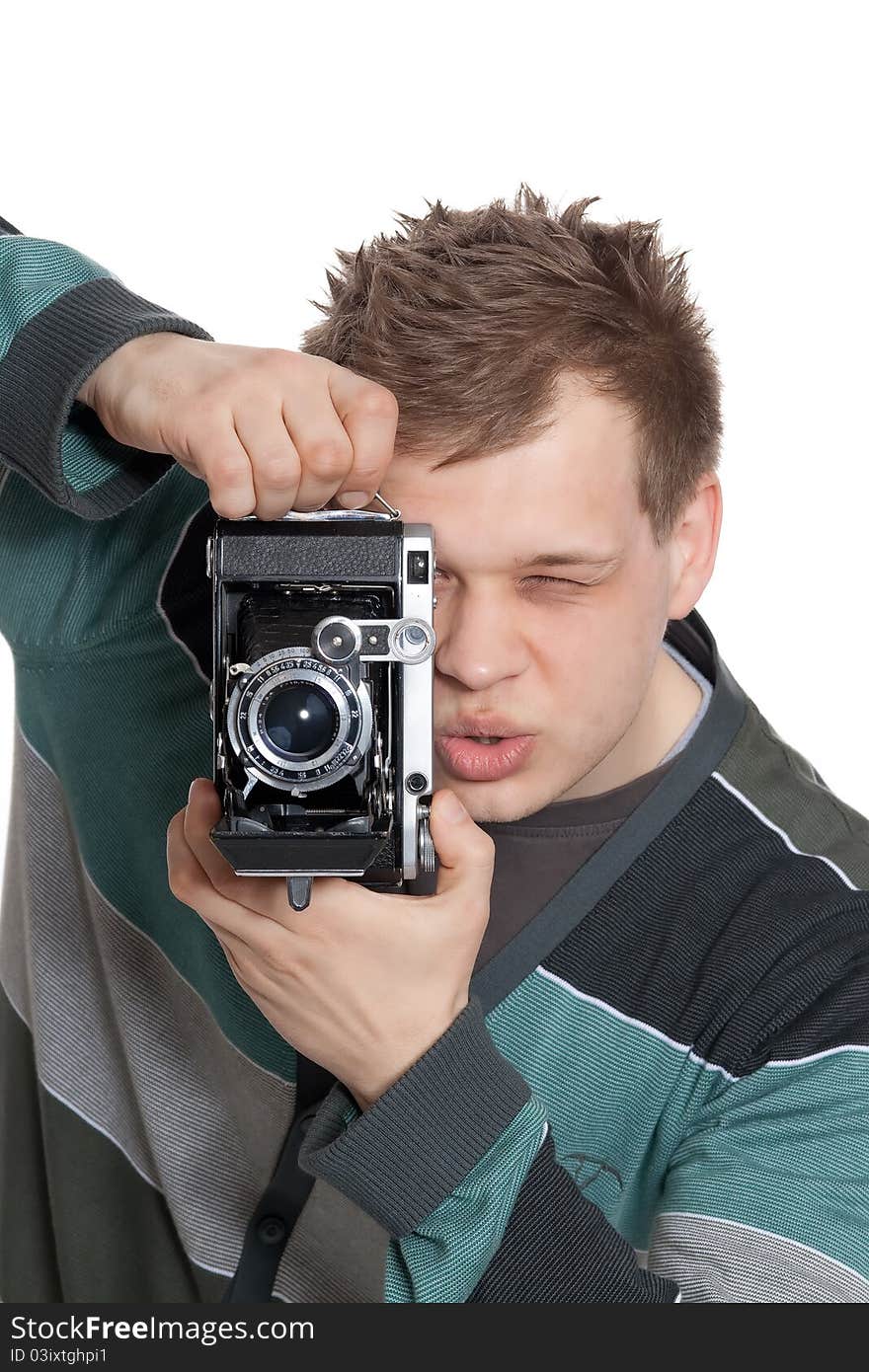 A young man is focused photographing old camera