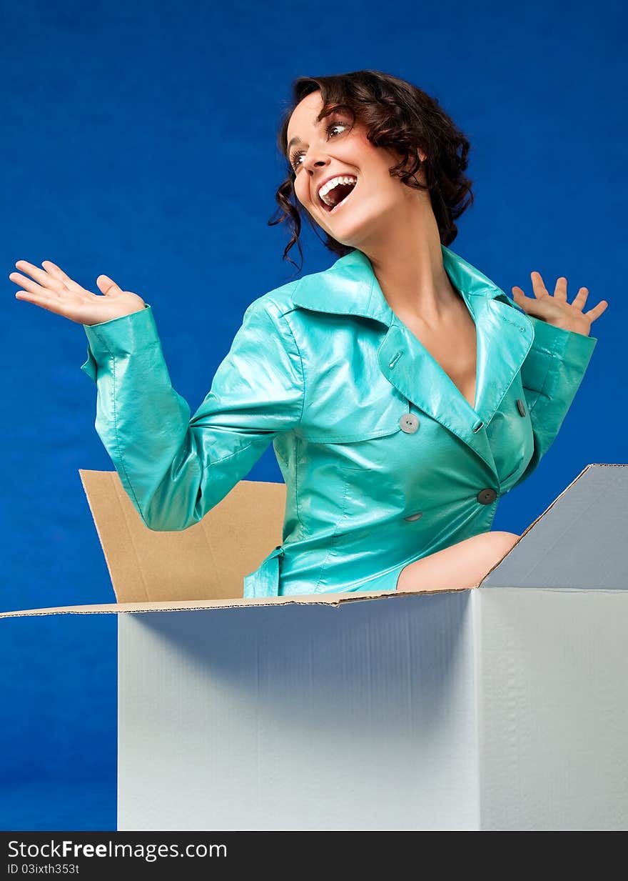 Beautiful woman coming out of cardboard box making surprise. Beautiful woman coming out of cardboard box making surprise