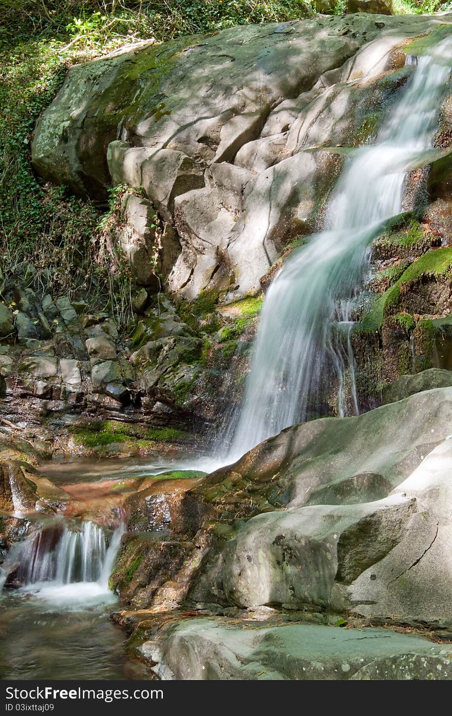 Springtime waterfall in woods of Tuscany with dappled sunlight. Springtime waterfall in woods of Tuscany with dappled sunlight