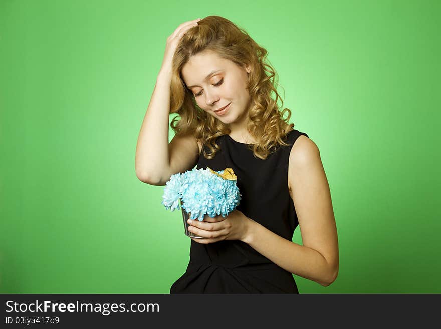 Close-up of an attractive young woman holding a gift bouquet of blue chrysanthemums sits on colors yellow butterfly. Close-up of an attractive young woman holding a gift bouquet of blue chrysanthemums sits on colors yellow butterfly