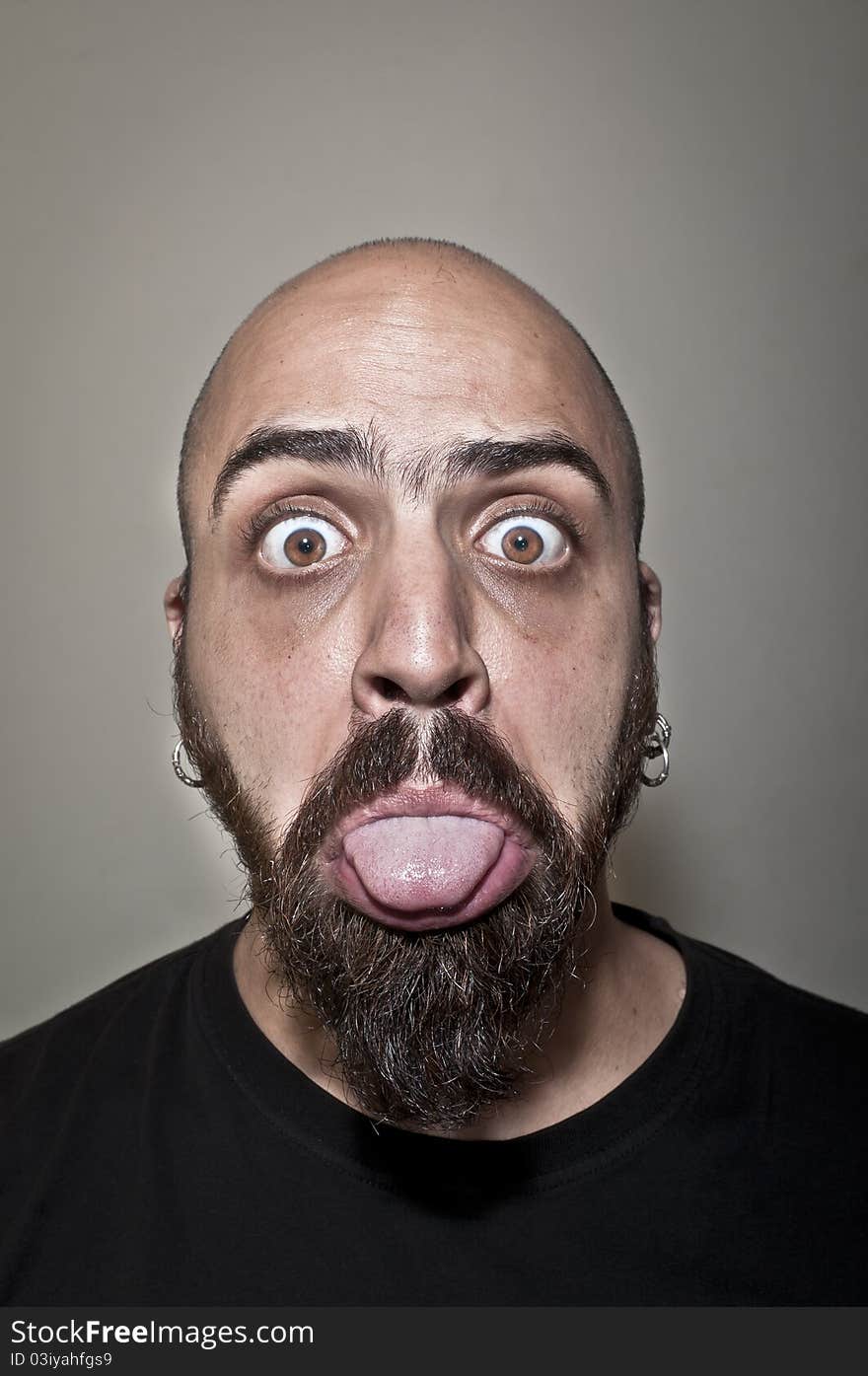 Man showing his tongue on grey background