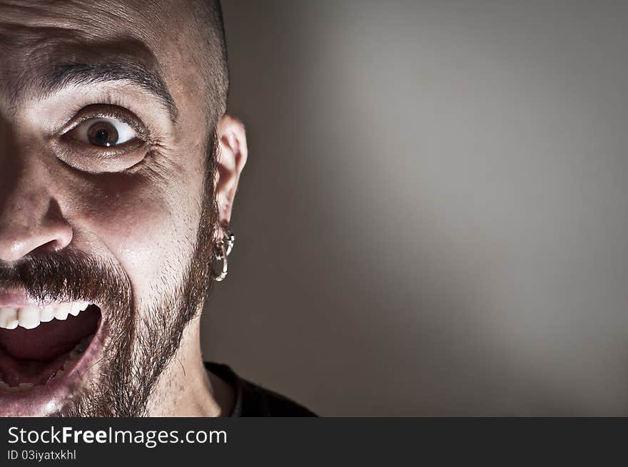 Mid-frontal portrait of a man yelling on grey background