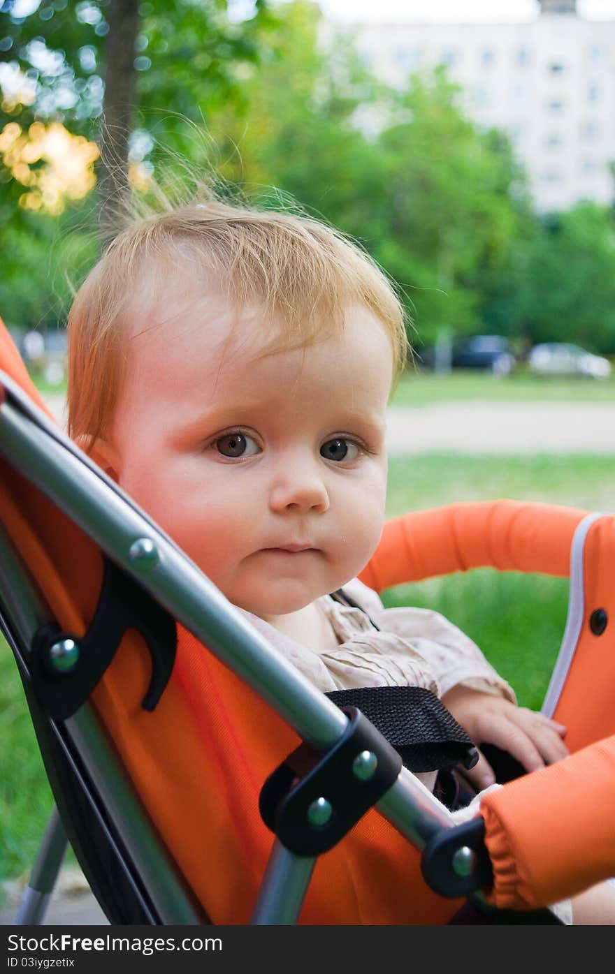 1 year old girl sitting in baby carriage. 1 year old girl sitting in baby carriage